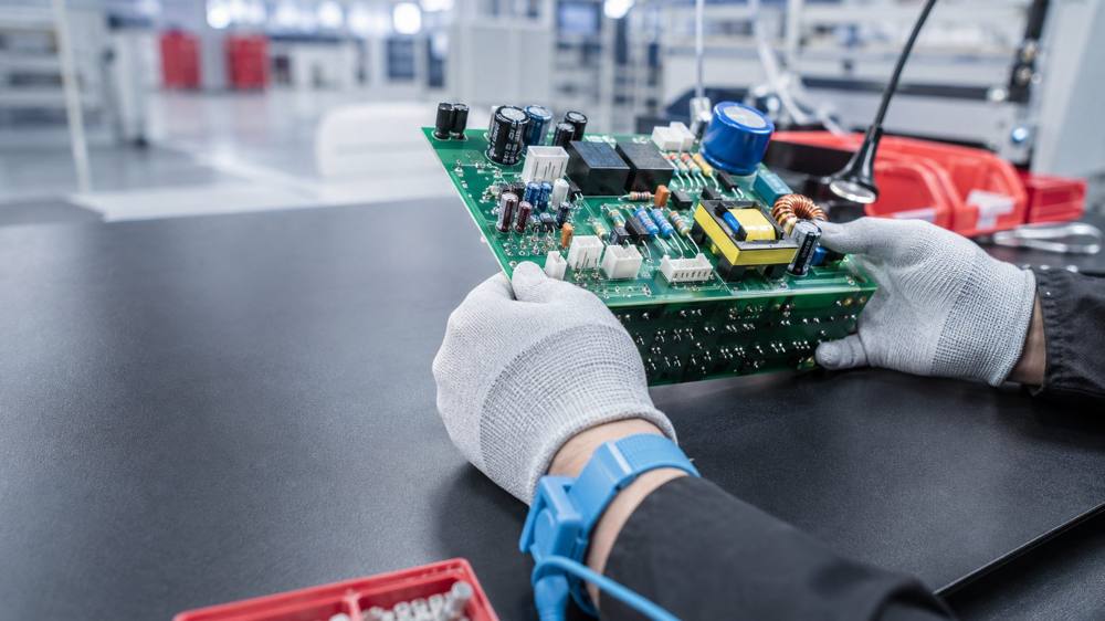 Technician inspecting a through-hole assembled PCB